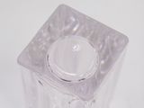a clear glass container with a lid on a white surface