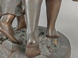 bronze statue of a boy and a girl with a basket of flowers