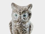 a figurine of an owl that is sitting on a table