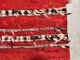 a close up of a piece of red fabric with black and white designs