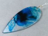 the pendant is made of glass and has a blue and black design