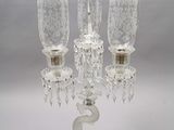 a glass candelab with three candles on top of it