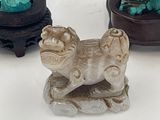 three small figurines of animals and a statue of a woman on a horse