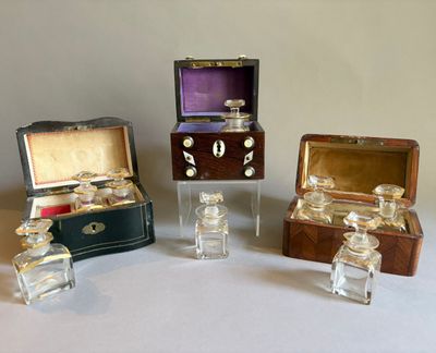 trois petits bocaux en verre et une petite boîte en bois posés sur une surface blanche