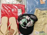 a hat, t - shirt, flip flops, and a pair of sandals on a table