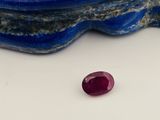 un gros plan d'un rubis rouge posé sur une pierre bleue