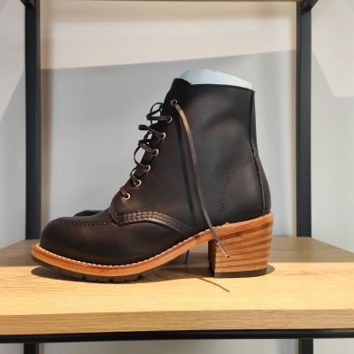 des bottines en cuir à lacets posées sur une étagère en bois dans une pièce
