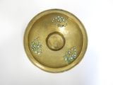 a gold plate with flowers on it on a white surface