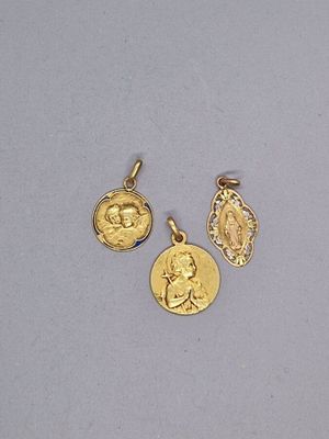 trois pendentifs en forme de pièces d'or représentant le visage d'une femme