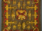 a square scarf with gold and red designs on it