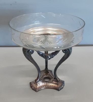 un saladier en verre posé sur un support, sur une table