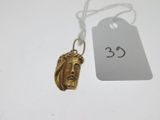 un gros plan sur un collier en or orné d'un visage de Jésus