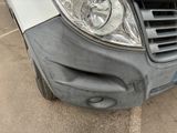 a close up of the front of a van with a denting headlight