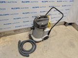 un aspirateur est posé par terre devant un mur
