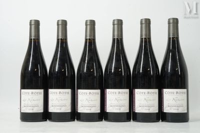 six bottles of wine are lined up in a row on a table
