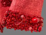 a close up of a bracelet with red beads on it