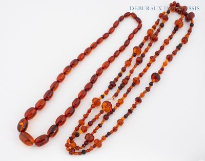 un gros plan sur trois rangées de perles d'ambre de la Baltique posées sur une surface blanche