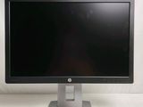 a computer monitor sitting on a stand on a white surface