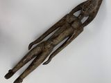 an old wooden sculpture of a man holding a knife on a white surface