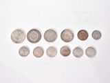 several different coins are arranged in a row on a white surface
