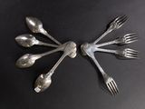 a lot of silver spoons and forks arranged in a circle