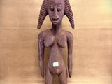 statue of a woman with a hat on her head on a wooden surface