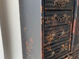a small black chest of drawers sitting on a table