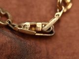 a close up of a gold chain with a clasp on it