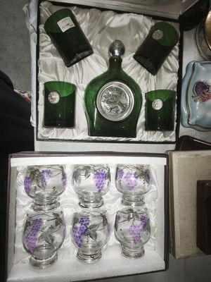 bottles and glasses in a box on a table next to a purse