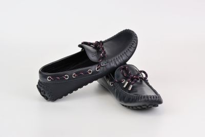 paire de mocassins noirs avec des lacets violets sur fond blanc