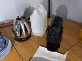 a table with a tea kettle, a coffee pot, a plate and a cup on it