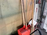 two brooms and a mop on a cart in a garage
