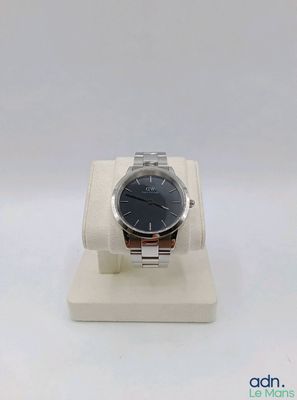 a watch that is sitting on a stand on a white surface