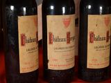 three bottles of red wine are lined up on a table