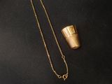 a gold cup and chain on a black background