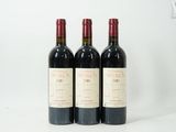 trois bouteilles de vin rouge sont alignées sur une surface blanche