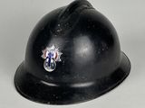un casque noir orné d'un insigne sur un fond blanc