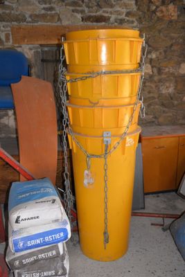 a large yellow bucket sitting next to a pile of boxes