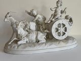 une statue représentant une calèche tirée par des chevaux, avec un homme et une femme à bord