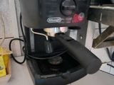 a coffee maker sitting on a counter next to a cup of coffee