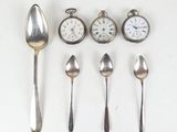 plusieurs cuillères en argent et des cuillères-cuillères, avec une horloge en arrière-plan