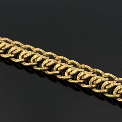 gros plan d'un bracelet en or sur une surface noire