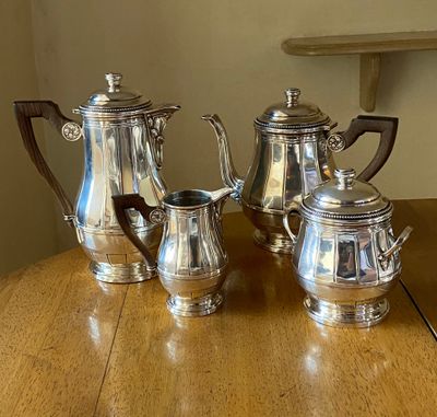 three silver coffee pots sitting on a wooden table