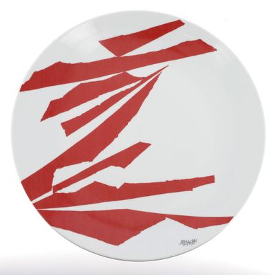 une assiette rouge et blanche sur laquelle sont posés des morceaux de papier déchirés