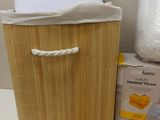 a bamboo basket with a towel on top of it next to a toilet