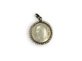 a close up of a coin in a pendant on a white background