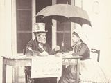 un homme et une femme assis à une table avec un parasol