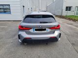 the rear end of a silver bmw car parked in a parking lot