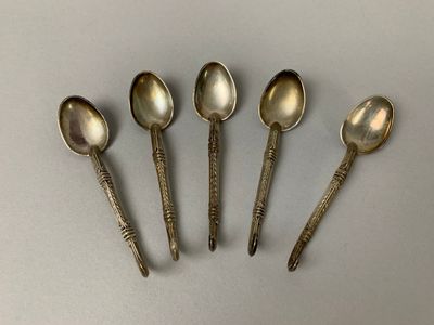 six cuillères sont alignées sur une table