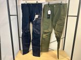 deux pantalons pour homme suspendus à un portant dans un magasin de vêtements